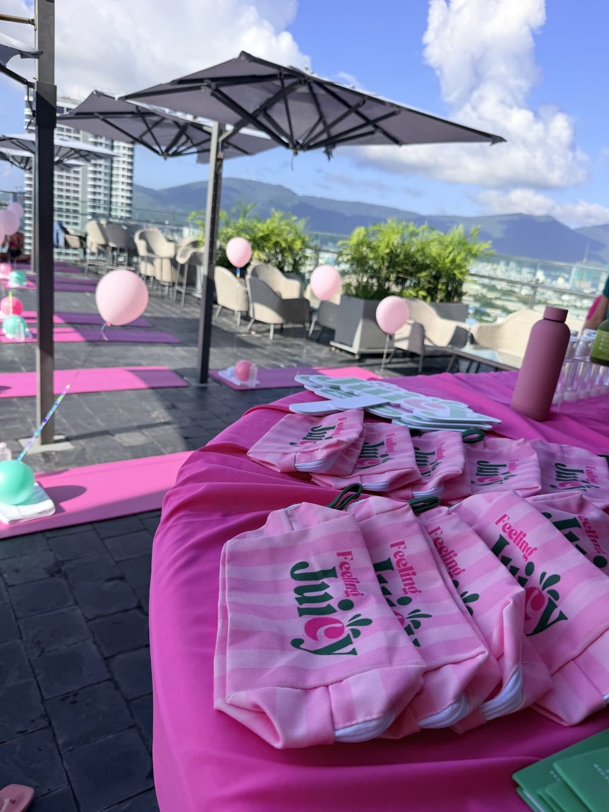 Yoga mats and Juicy bags set out for a class on a sunny rooftop