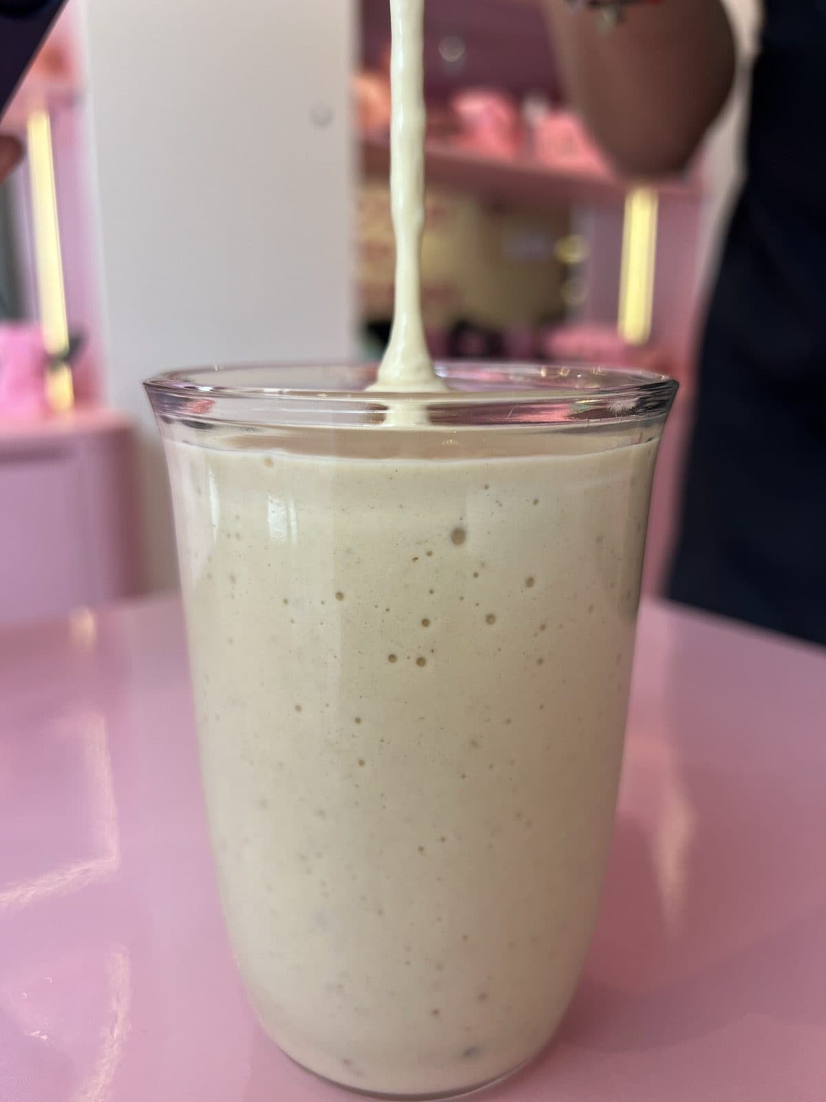 A shake being poured into a glass at Juicy