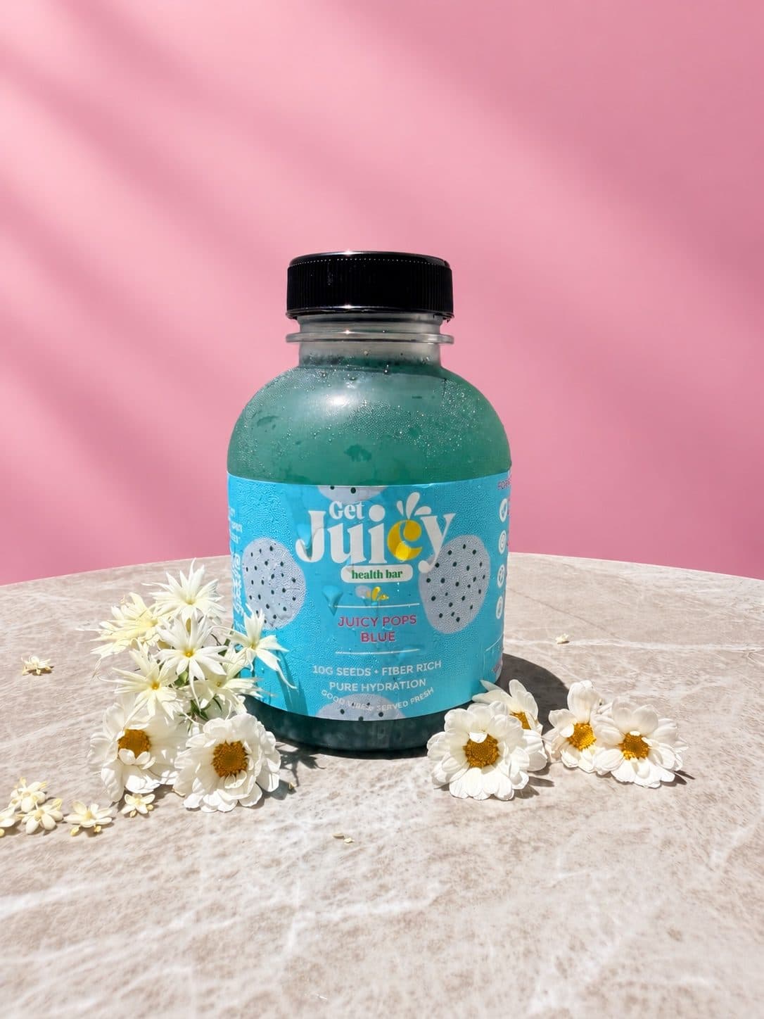 A bottle of Juicy Pops Blue with flowers